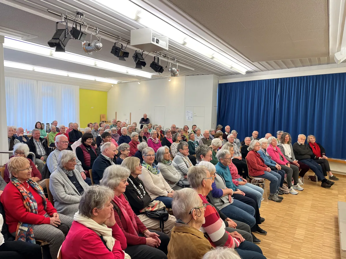 Etwa 80 Personen sitzen auf Stühlen im refomierten Kirchgemeindehaus.